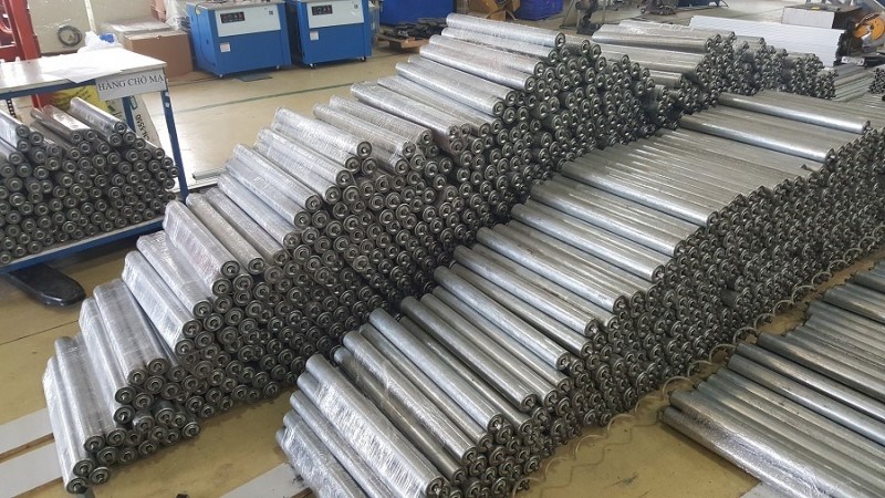 Hệ thống băng tải công nghiệp và ứng dụng con lăn thép mạ kẽm trong sản xuất cửa cuốn